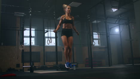 female-athlete-in-the-gym-jumping-rope-with-perspiration-performing-double-jumps